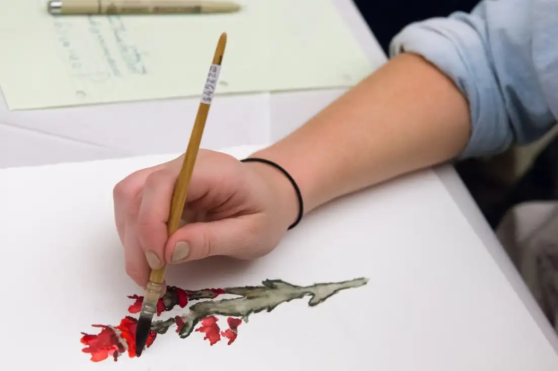 person painting a flower